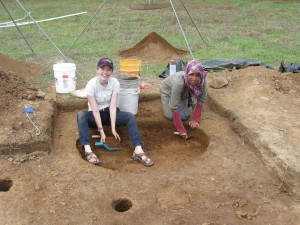 Students excavating a large circular feature in front of Structure 1.