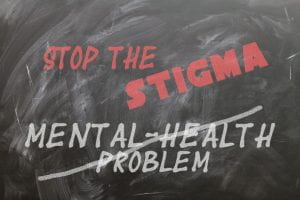 Chalkboard with words "Stop the Sigma, Mental Health Problems." Mental Health problems has a diagonal strike through it.
