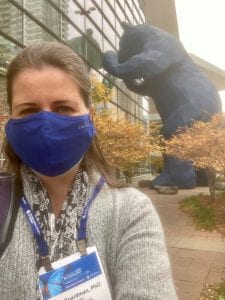 Dr. Boardman stands outside the Denver Convention Center with the "big blue bear" statue in the background